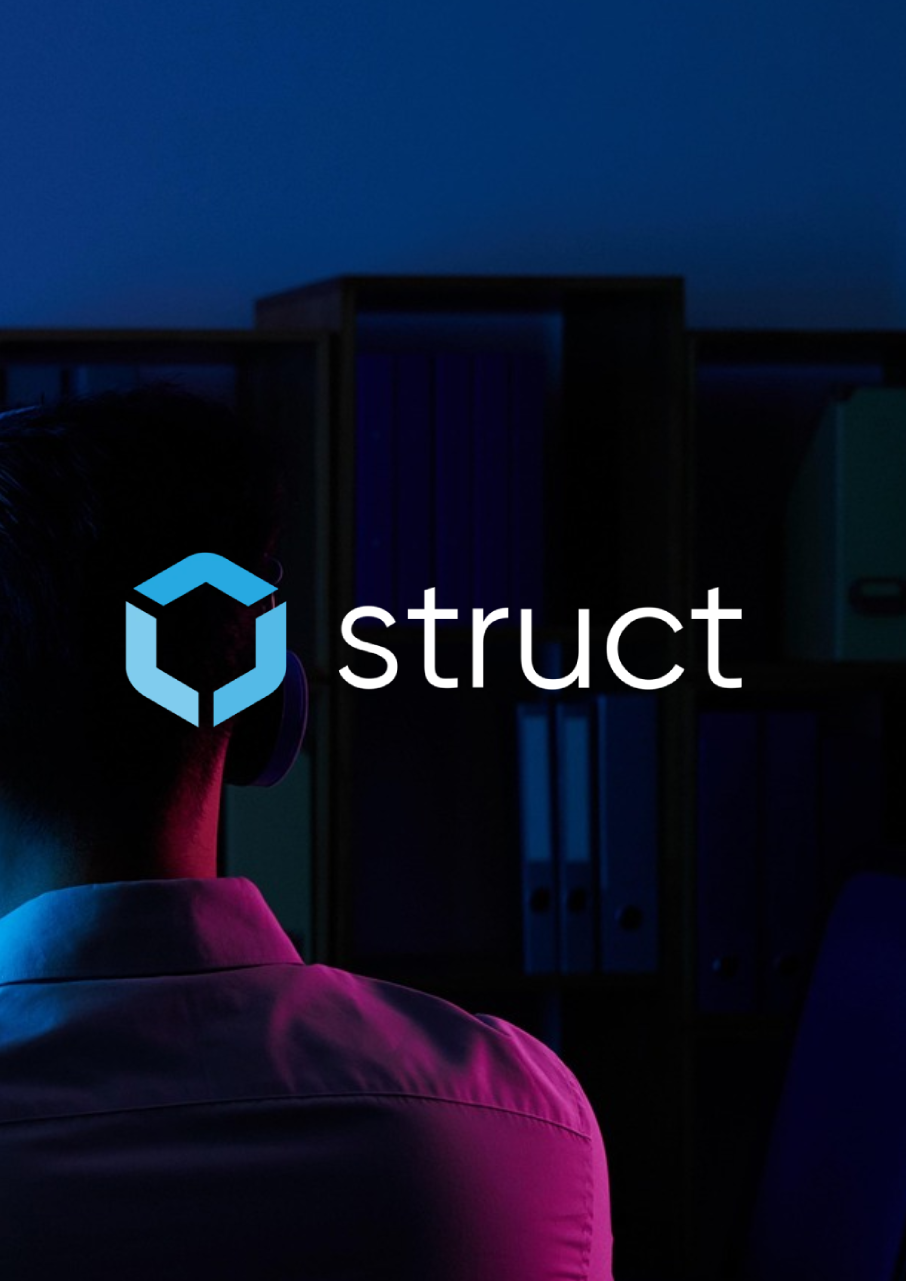 En person med hörlurar och skjorta, fotad bakifrån, en bokhylla i bakrunden, cerise och mörklblå ljuseffekter.